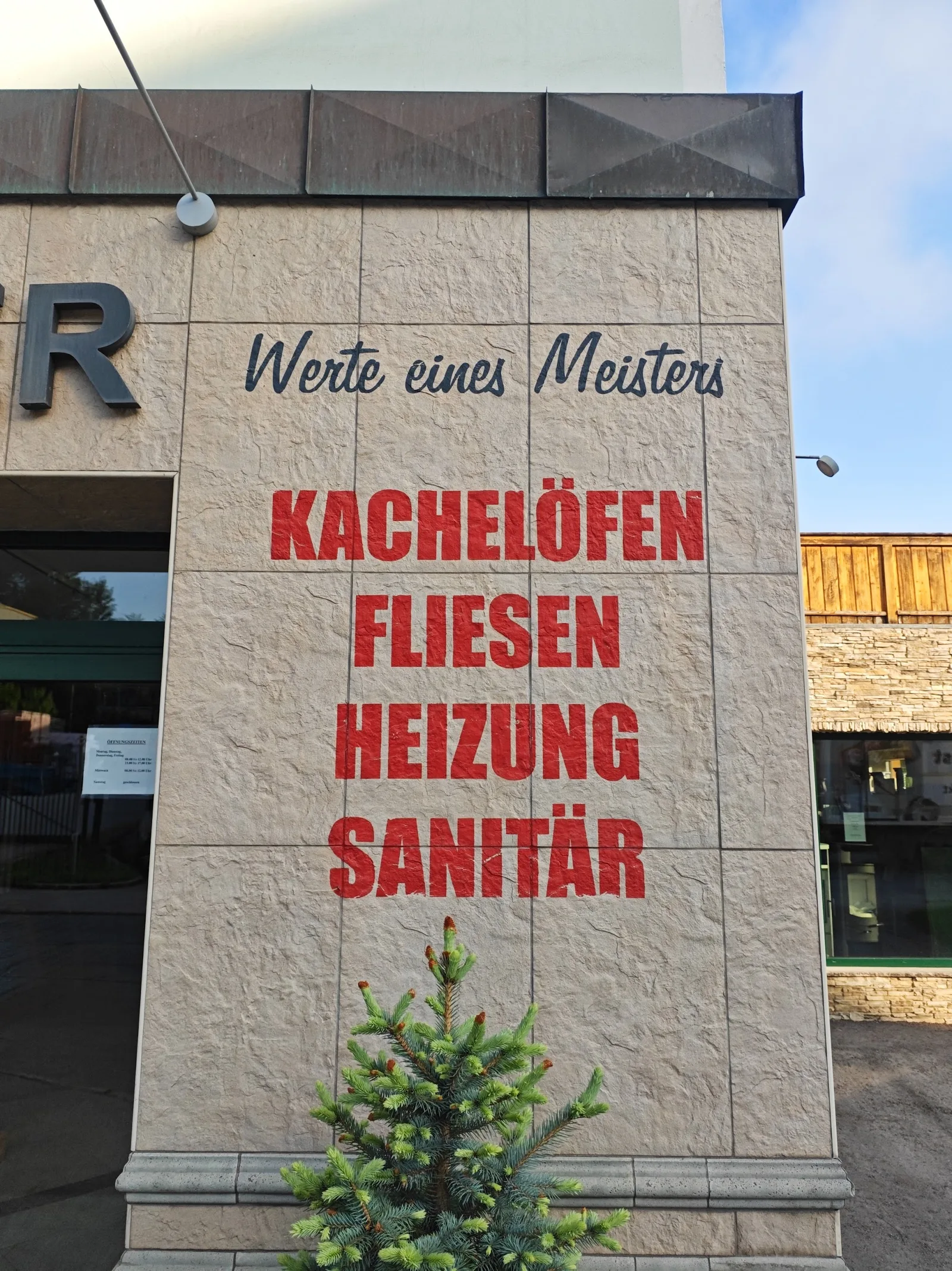 Fassade mit der Aufschrift Werte eines Meisters und darunter Kachelöfen, Fliesen, Heizung, Sanitär in roter Schrift